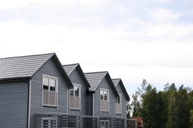 Photo of Beautiful modern grey houses against cloudy sky