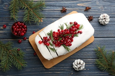 Photo of Flat lay composition with traditional classic Christmas cake with cranberries, pomegranate seeds and rosemary on blue wooden table