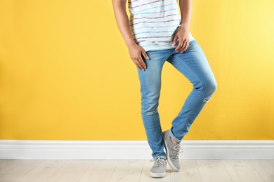 Photo of Young man in stylish jeans near color wall