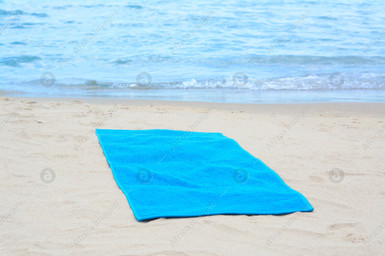 Photo of Blue towel on sandy beach near sea