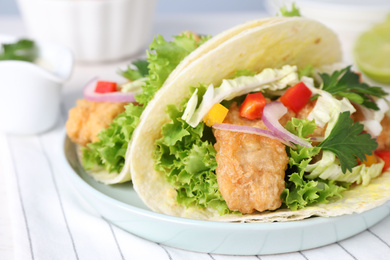 Photo of Yummy fish tacos served on table, closeup