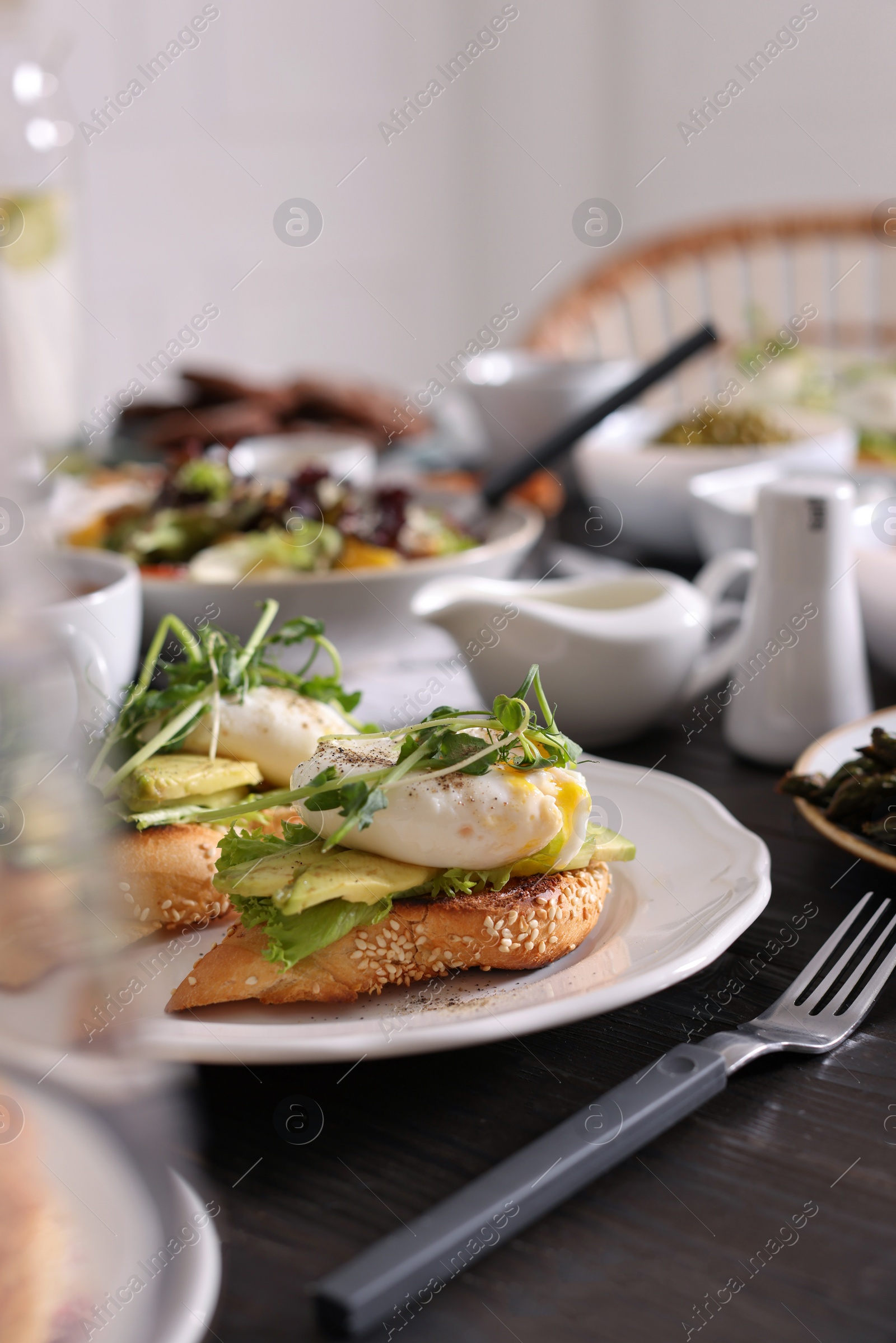 Photo of Delicious sandwiches with eggs and avocado served on buffet table for brunch