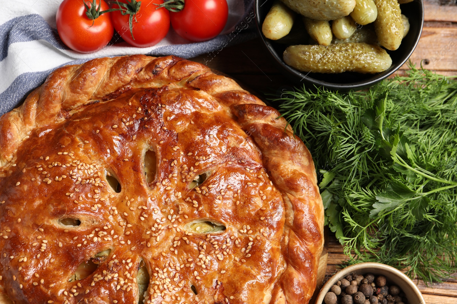 Photo of Tasty homemade pie and ingredients on wooden table, flat lay