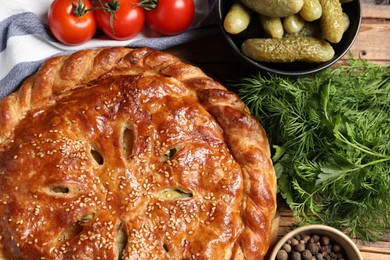 Tasty homemade pie and ingredients on wooden table, flat lay