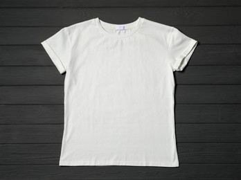 Stylish white T-shirt on gray wooden table, top view