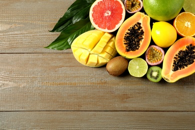 Fresh ripe papaya and other fruits on wooden table, flat lay. Space for text