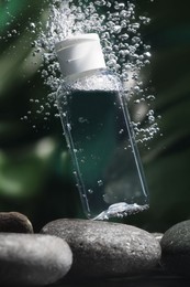 Photo of Bottle of micellar water in liquid on blurred background