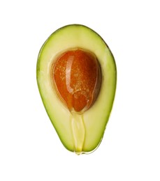 Photo of Pouring cooking oil onto fresh cut avocado on white background