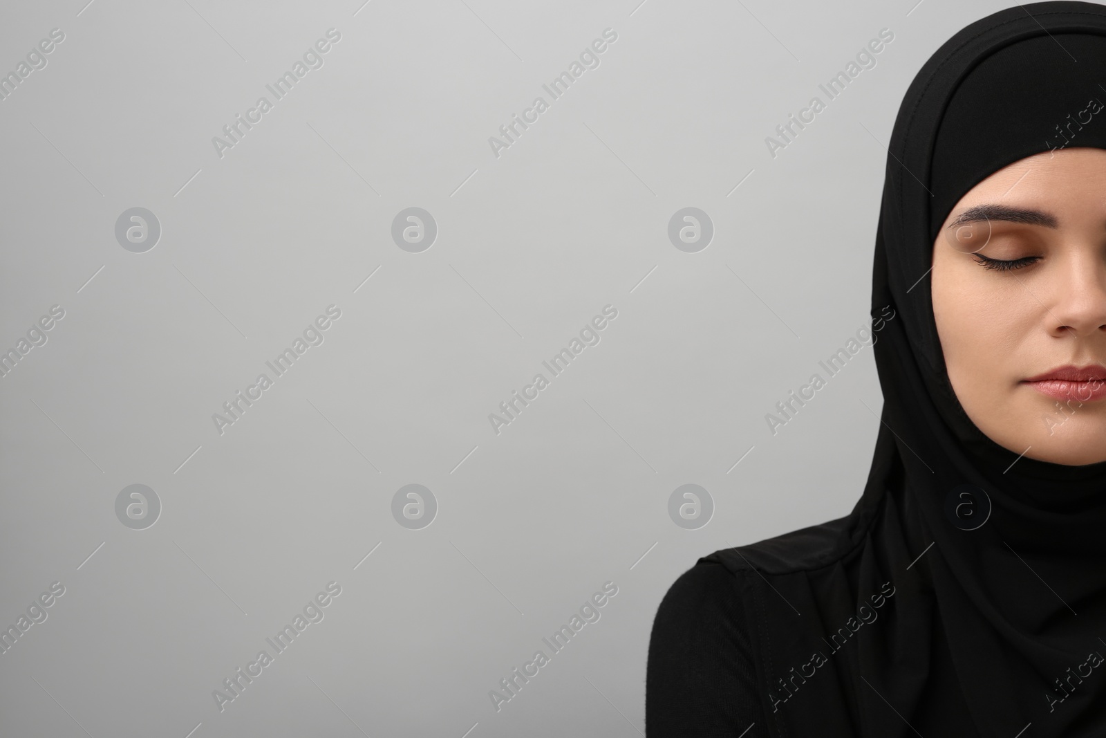 Photo of Muslim woman in hijab on light gray background, space for text