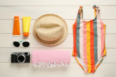 Different beach objects on white wooden background, flat lay