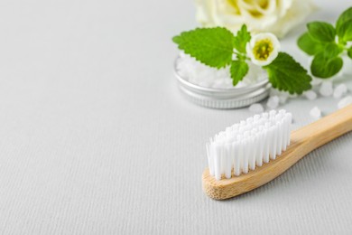 Photo of Toothbrush, salt and herbs on white background, closeup. Space for text