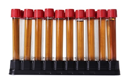 Photo of Test tubes with brown liquid in stand on white background