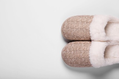 Pair of beautiful soft slippers on white background, top view. Space for text