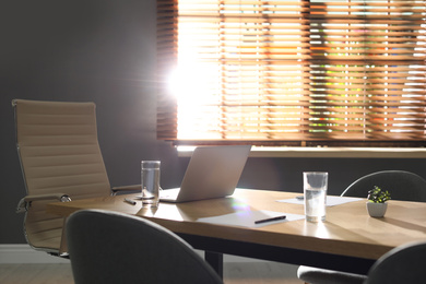 Laptop on wooden table in modern office