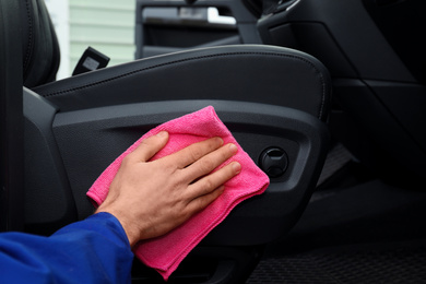 Photo of Car wash worker cleaning automobile interior, closeup