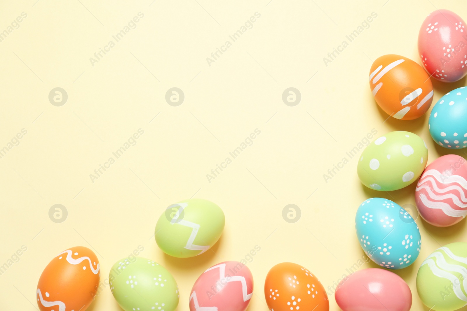 Photo of Flat lay composition of painted Easter eggs on color background, space for text