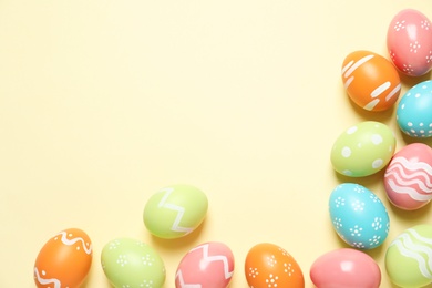 Photo of Flat lay composition of painted Easter eggs on color background, space for text