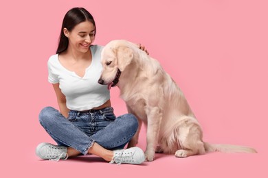 Photo of Happy woman with cute Labrador Retriever dog on pink background. Adorable pet