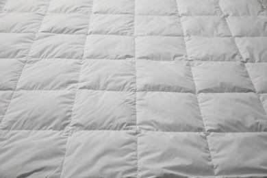 Soft quilted blanket as background, closeup view