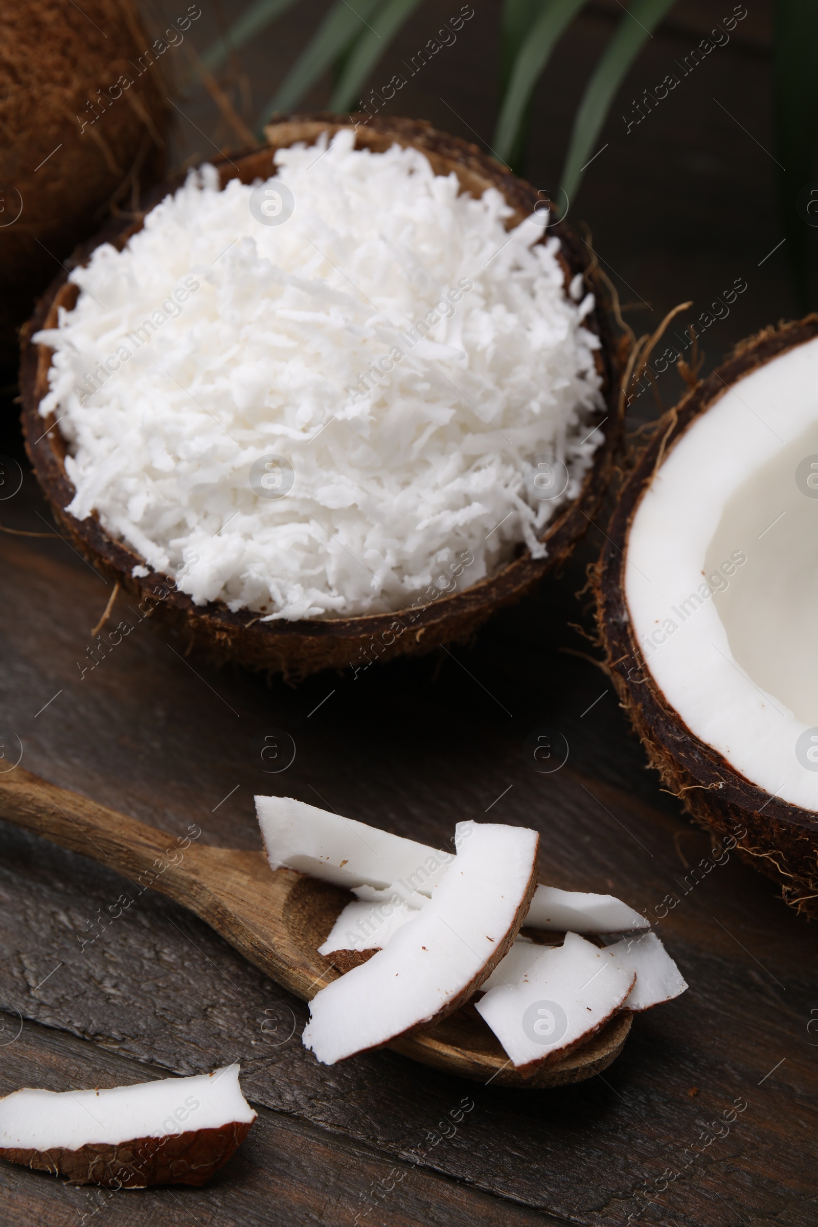 Photo of Coconut flakes, spoon and nut on wooden table