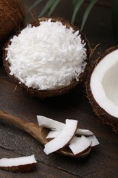 Coconut flakes, spoon and nut on wooden table