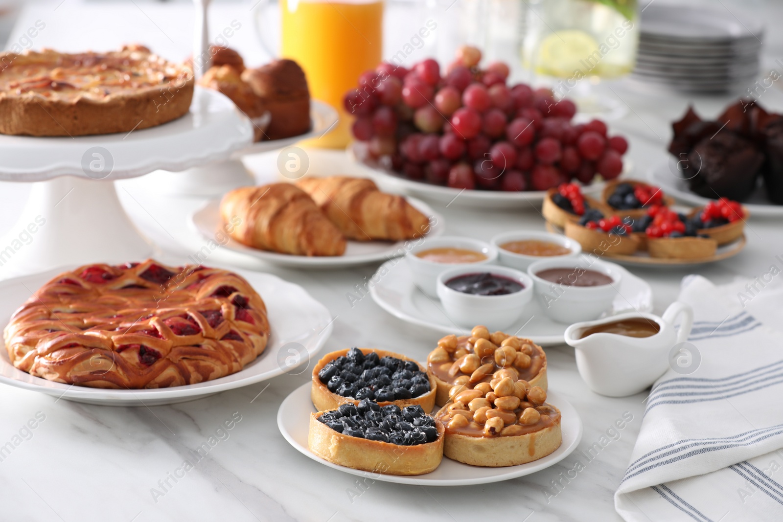 Photo of Variety of snacks on white marble table in buffet style