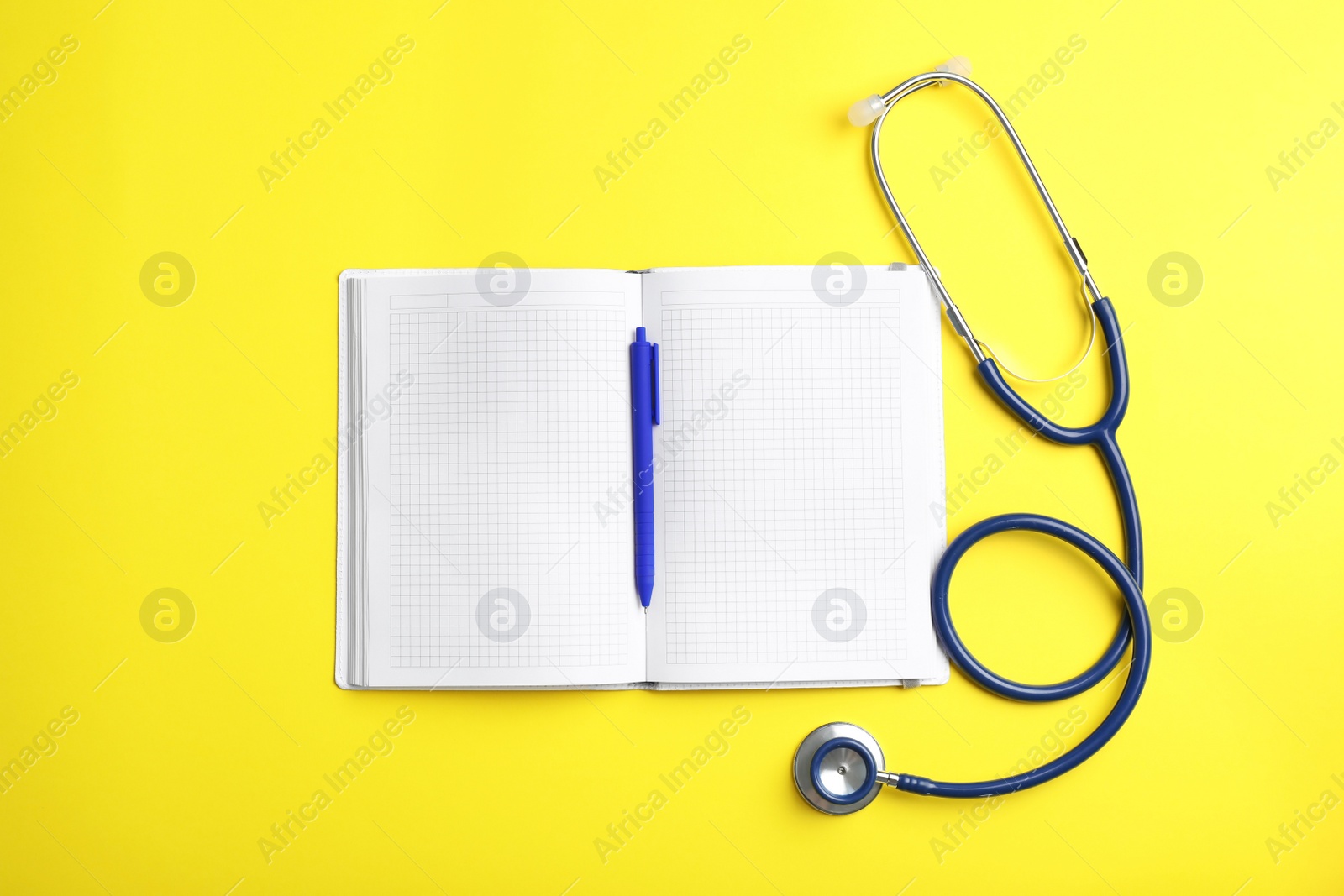 Photo of Copybook with pen and stethoscope on color background, flat lay. Medical care