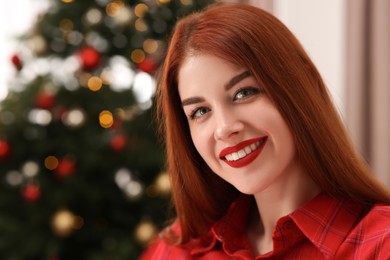 Photo of Beautiful young woman against blurred lights, closeup and space for text. Celebrating Christmas