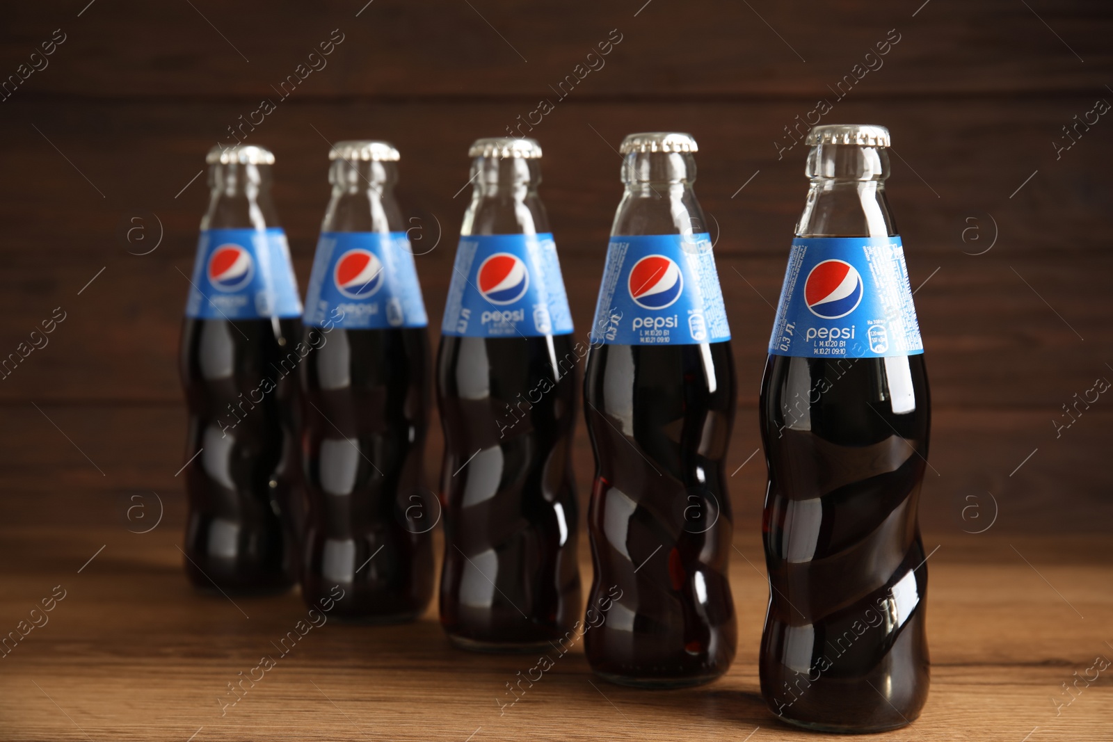 Photo of MYKOLAIV, UKRAINE - FEBRUARY 9, 2021: Many bottles of Pepsi on wooden table