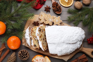 Traditional Christmas Stollen with icing sugar on wooden table, flat lay