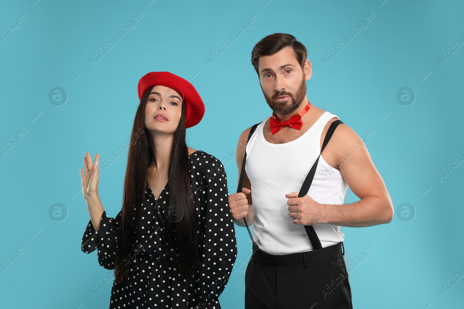 Photo of Beautiful couple posing together on light blue background