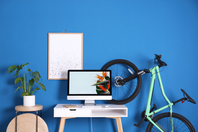 Photo of Stylish room interior with modern green bicycle and workplace
