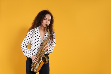 Beautiful African American woman playing saxophone on yellow background. Space for text