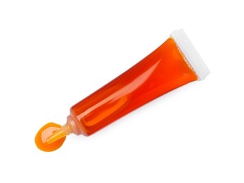 Photo of Tube with orange food coloring isolated on white, top view