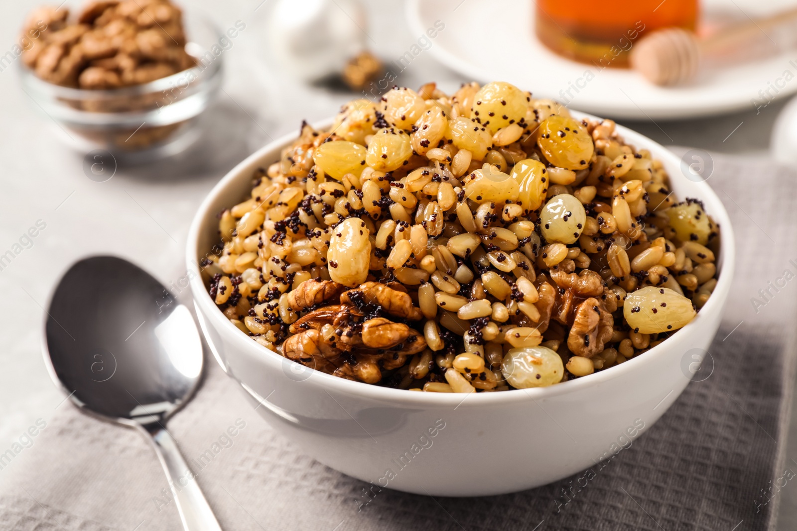 Photo of Traditional Christmas slavic dish kutia in bowl on napkin, closeup