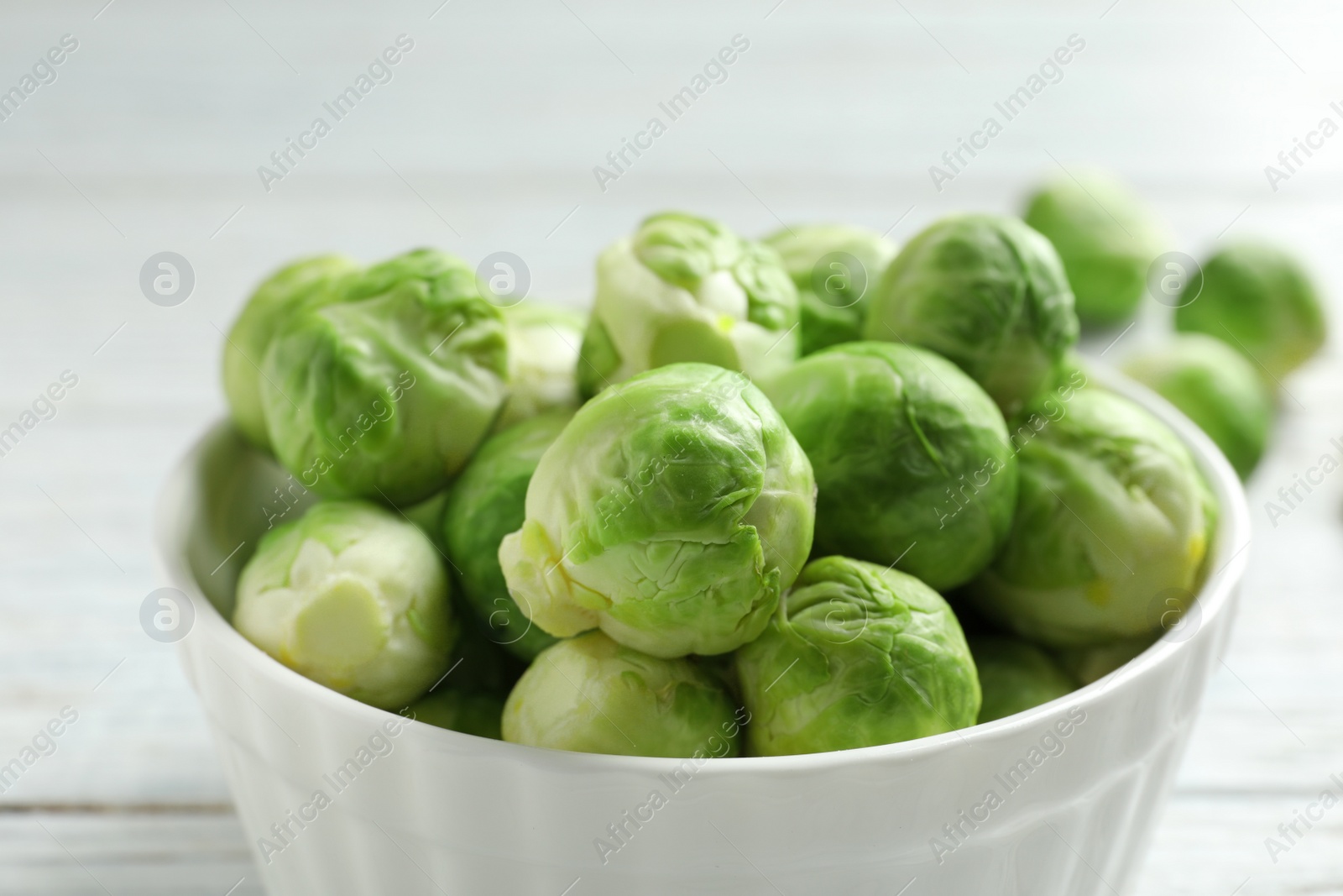 Photo of Bowl of fresh Brussels sprouts on table, closeup