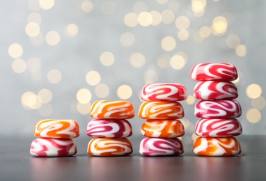 Photo of Stacked tasty hard candies on grey table