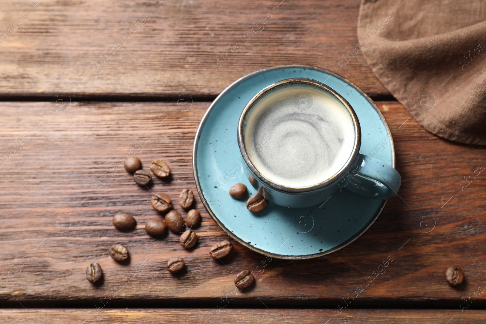 Photo of Turkish coffee. Freshly brewed beverage and beans on wooden table, above view. Space for text