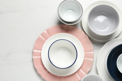 Photo of Beautiful ceramic dishware on white marble table, flat lay. Space for text