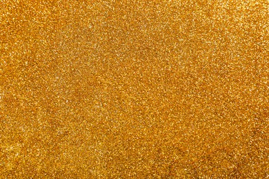 Photo of Shiny bright golden glitter as background, top view