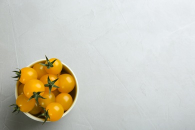 Photo of Ripe yellow tomatoes on grey table, top view. Space for text