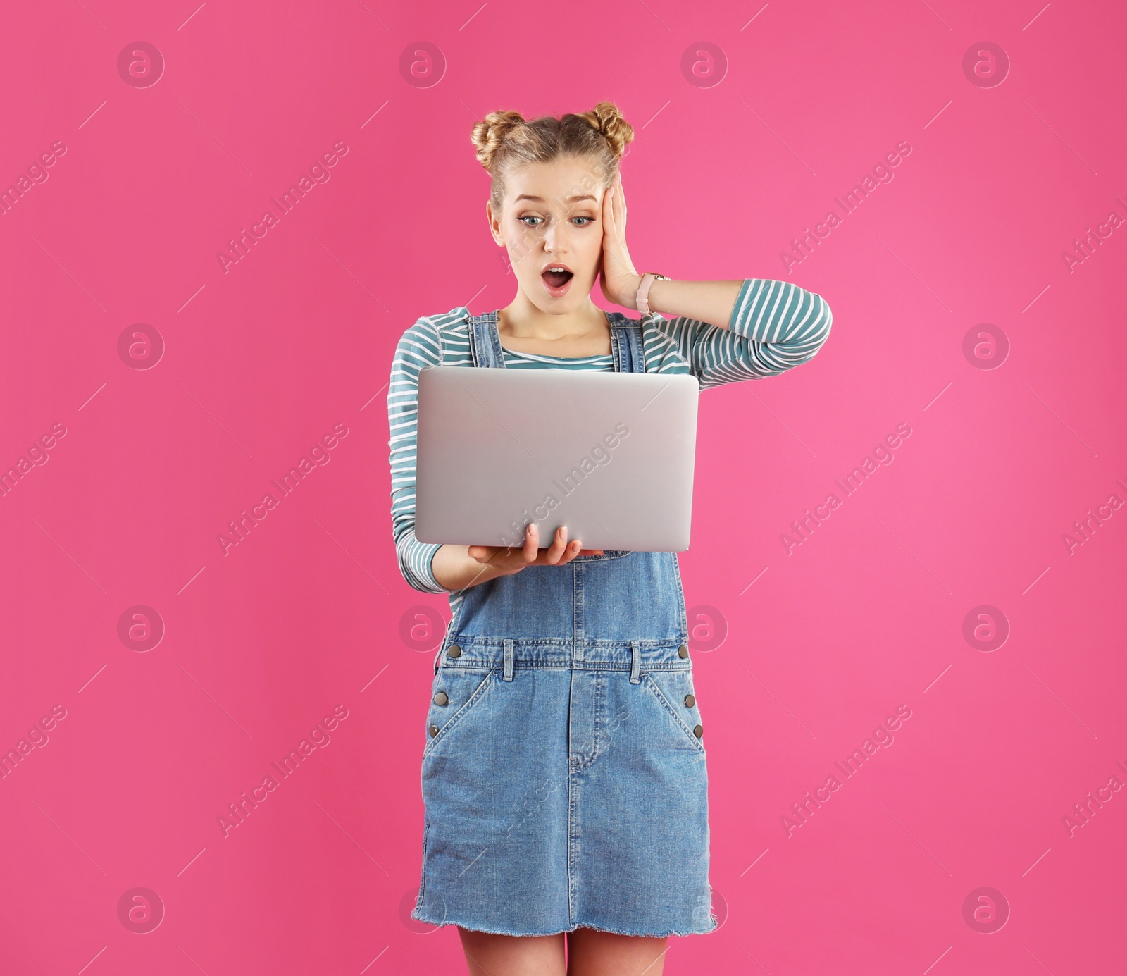 Photo of Portrait of young woman with laptop on pink background