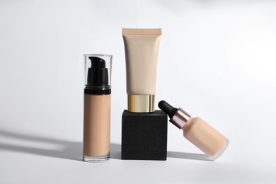 Photo of Bottles and tube of skin foundation on white background. Makeup product