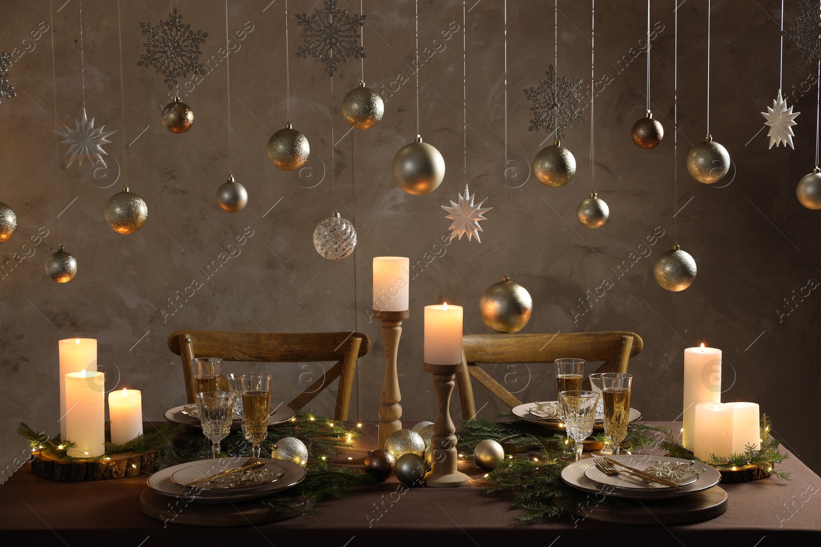 Photo of Christmas table setting with burning candles and festive decor