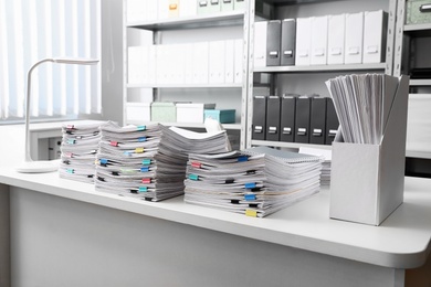 Photo of Table with lots of documents in office