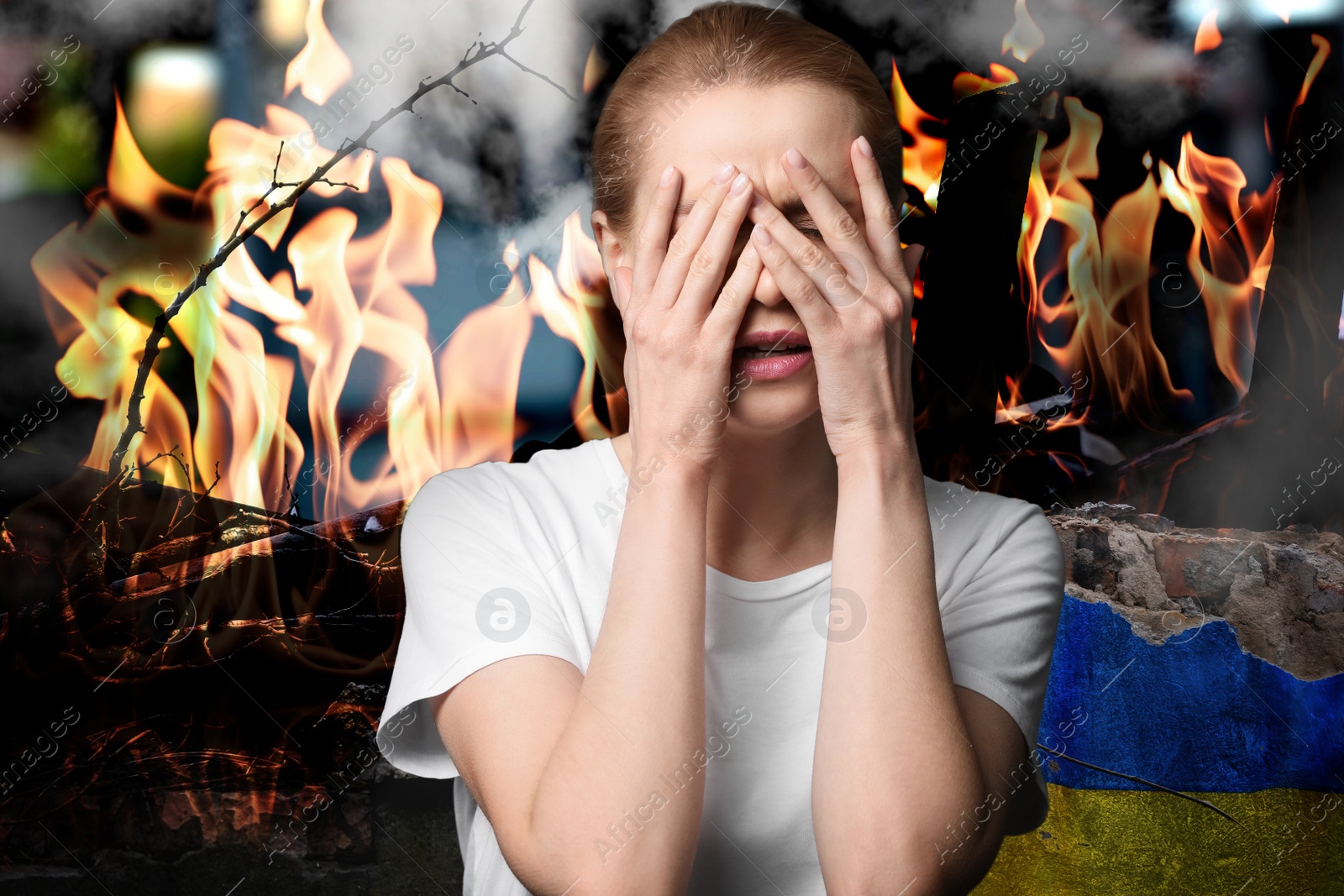 Image of Upset woman near wall of ruined building painted in color of national flag on fire. Stop war in Ukraine