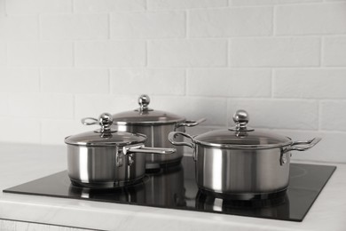 Photo of Set of new clean cookware on cooktop in kitchen