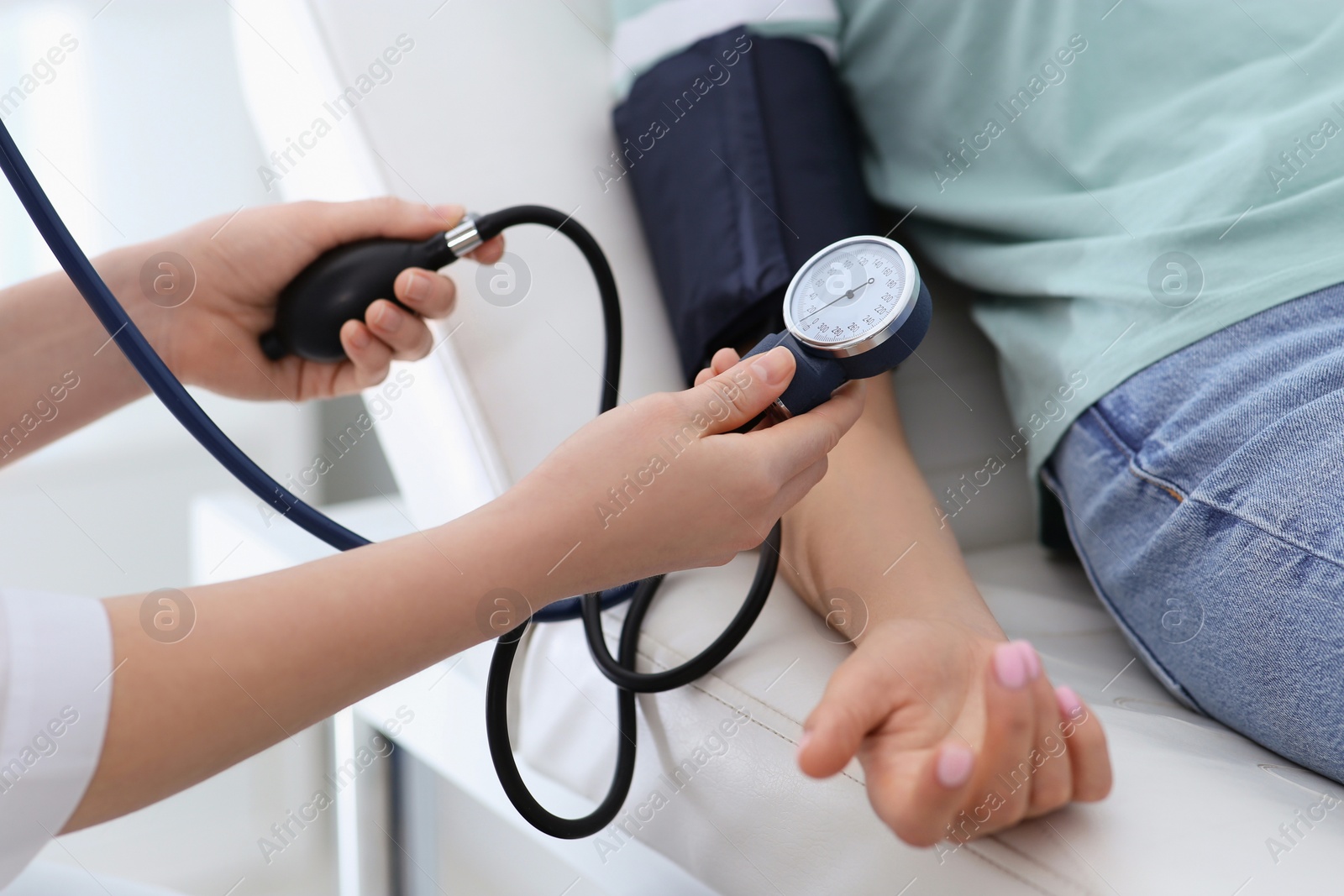 Photo of Doctor checking blood pressure of woman in clinic, closeup