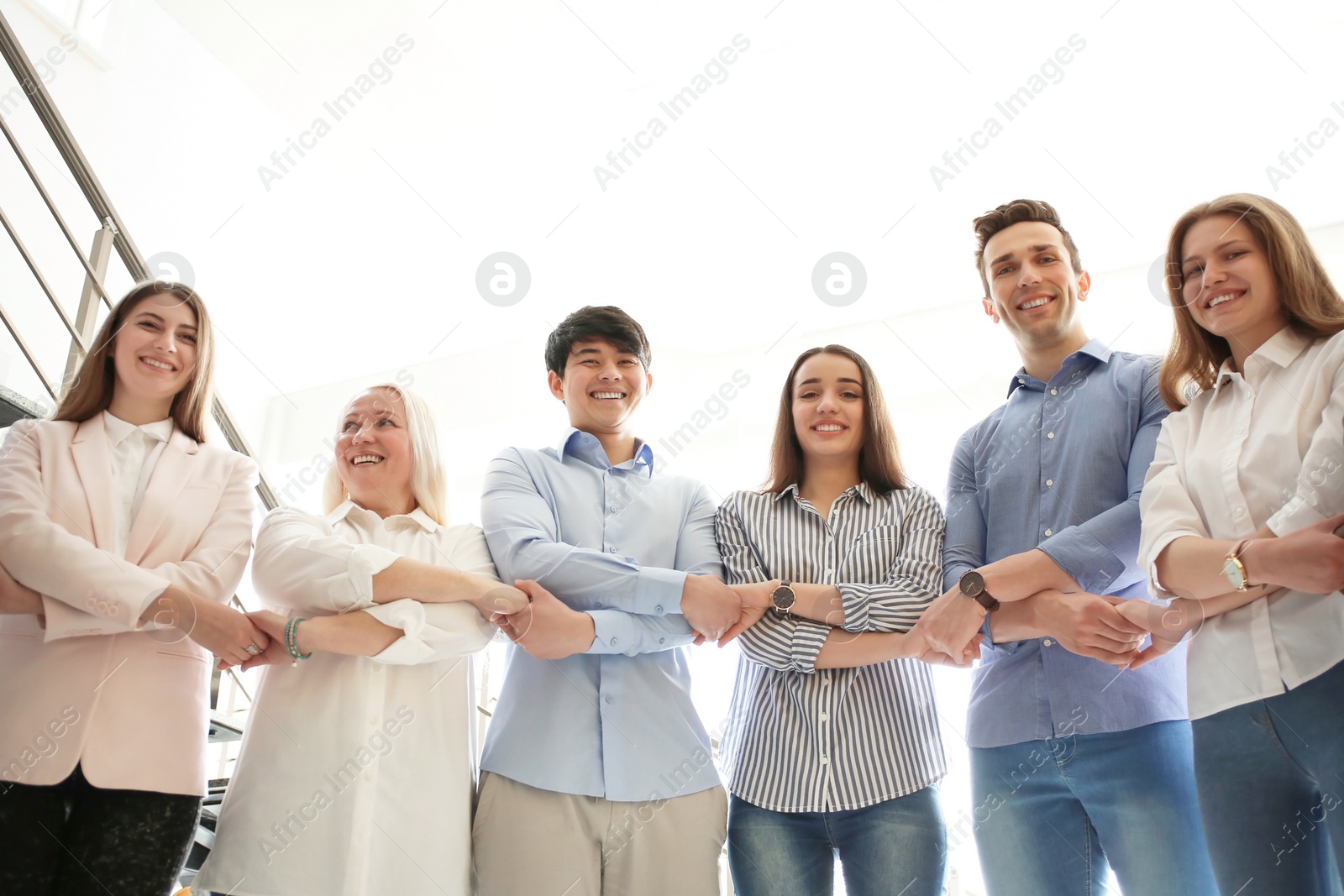 Photo of People holding hands indoors. Unity concept