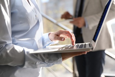 Image of Woman using modern laptop with switched on VPN in office, closeup